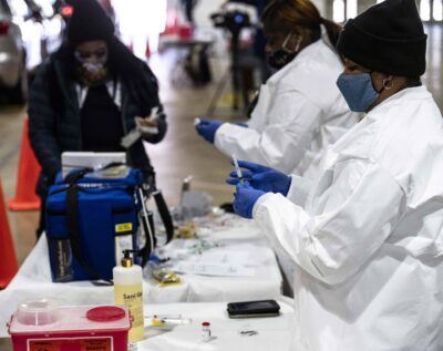 Health care workers prepare to administer the COVID-19 vaccine.