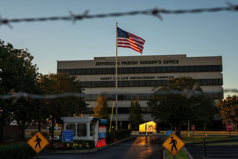 A five-story modern building with a large U.S. flag out front