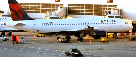 A police car patrols past a Delta jet at the Detroit Metropolitan Airport on Dec. 26, 2009, one day after a Nigerian man allegedly attempted to blow up a different Delta airplane that was landing at the airport by igniting an incendiary device while aboard the aircraft. Homeland Secretary Janet Napolitano has called for increasing the number of federal air marshals in light of that attempted attack. (Bill Pugliano/Getty Images)