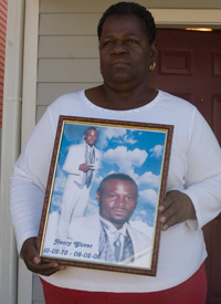 Edna Glover holds a portrait of her son, whose charred remains were found behind a police station. (Credit: Chandra McCormick & Keith Calhoun)