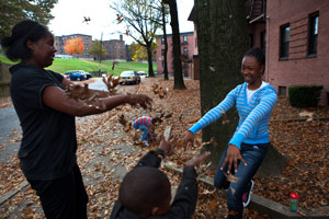 Cherie Michaux, left, with her daughter Ja'liza Michaux, 12, right, and son Ja'kye Brown, 7, center foreground, and her nephew Quaheem Moreau, 3, background, playing with leaves in Port Chester, N.Y., on Oct. 27. (Melanie Burford for ProPublica)